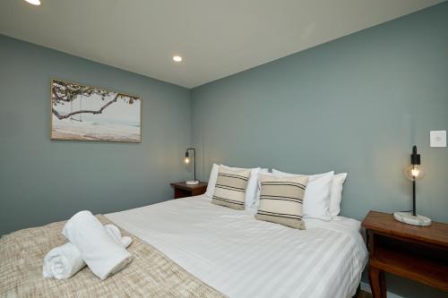 a bedroom with a bed with white sheets and pillows at Modern Mountain Views Sunny in Kaikoura