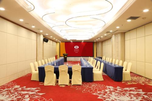 a conference room with blue tables and white chairs at Asia International Hotel Guangdong in Guangzhou
