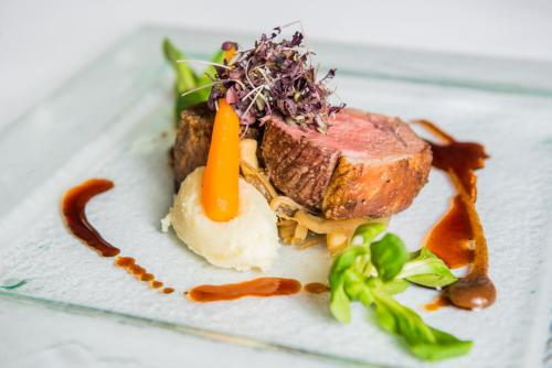 a plate of food with meat and vegetables on it at The Coed-Y-Mwstwr Hotel in Bridgend