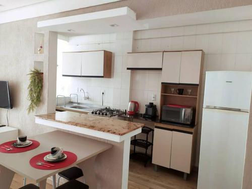 a kitchen with white cabinets and a white refrigerator at Ótimo apto na melhor localização! lado do Hospital in Santa Maria