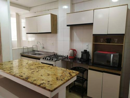 a kitchen with a counter top and a microwave at Ótimo apto na melhor localização! lado do Hospital in Santa Maria