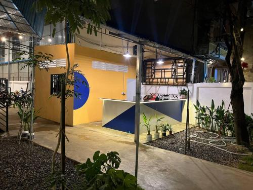 a room with plants and a yellow and blue wall at Por Chey Guesthouse in Battambang