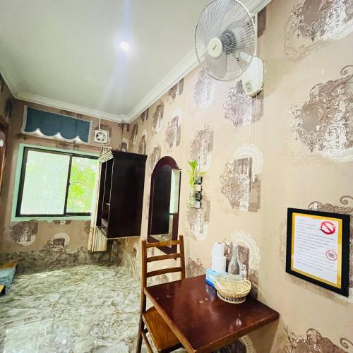 a room with a table and a fan on a wall at Por Chey Guesthouse in Battambang