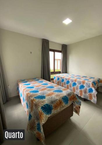 a bedroom with two beds and a window at Chalé Exclusivo Condomínio Águas da Serra in Bananeiras