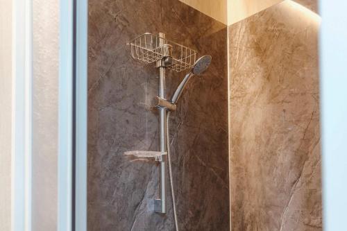 a shower with a shower head on a wall at Jade in the Wilderness 1 by Tiny Away in Ta-hu