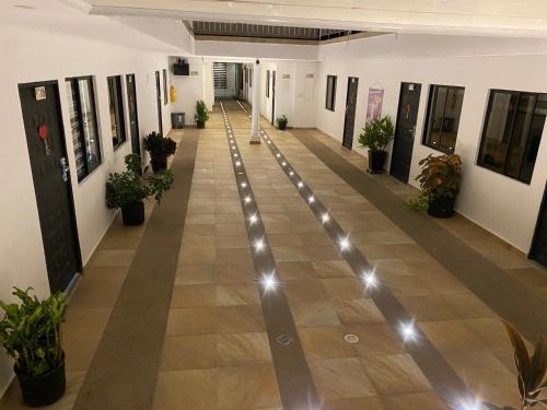 an empty hallway with potted plants and lights at Hotel deluxe oasis de la colina boutique in Girardot