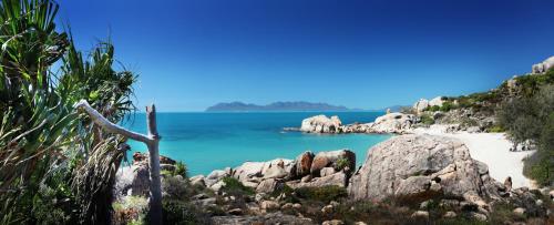 a view of a beach with rocks and the ocean at Whitsunday Sands Resort in Bowen