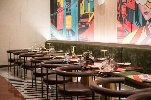 a row of tables with chairs in a restaurant at M Social Hotel Phuket in Patong Beach