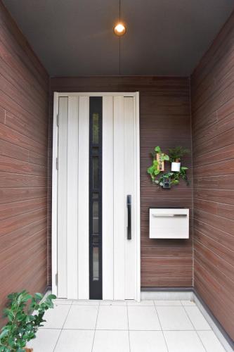 a door to a house with a plant on it at アキラ商事 in Tokyo