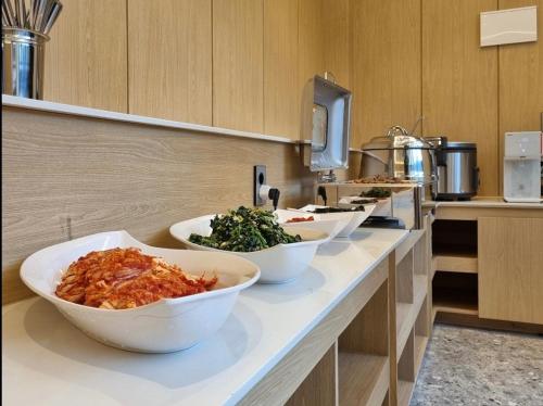 a kitchen with bowls of food on a counter at Hound Hotel Jeonju Deokjin in Jeonju