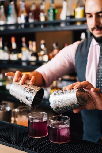 a bartender is making drinks in a bar at M Social Hotel Phuket in Patong Beach
