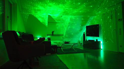a living room with green lights on a wall at SAUNA - MASSAGE -Bodensee-Cinema Feeling- Home Sharing - Parking - Küche in Radolfzell am Bodensee