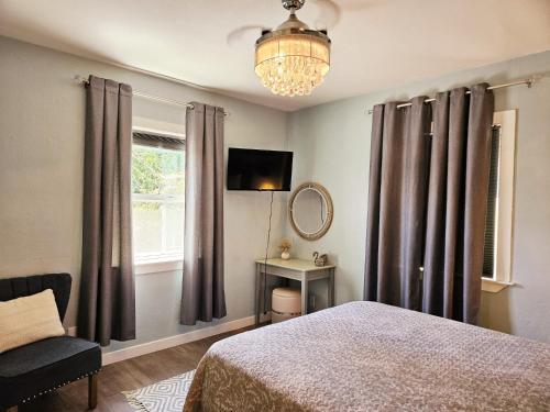 a bedroom with a bed and a chair and a window at Garden Clara in Yuba City