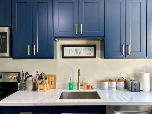 a kitchen with blue cabinets and a sink at Modern Deluxe Kitchen, King Bed, Laundry, DT Renton close to Valley Med & SeaTac in Renton