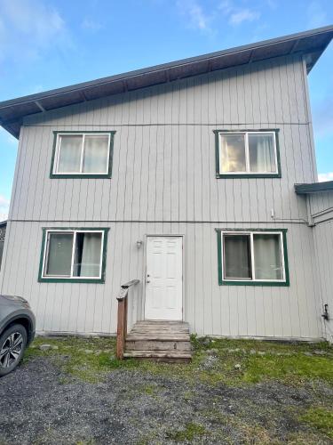 a white house with a white door and windows at Marina Motel in Seward