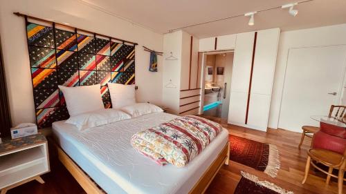 a bedroom with a bed with a wall of wine bottles at The Bolthole - Charteris Bay Holiday Home in  Lyttelton