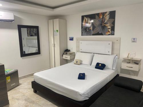 a bedroom with a large white bed in a room at Hotel deluxe oasis de la colina boutique in Girardot