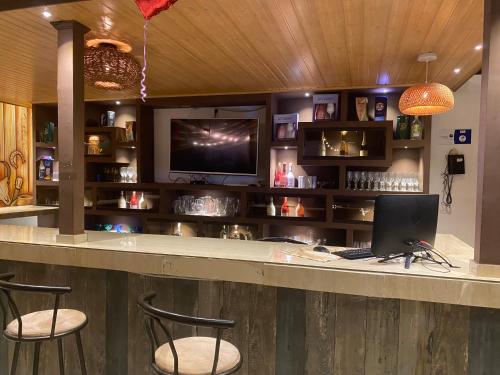 a bar with two chairs and a computer on a counter at Hotel deluxe oasis de la colina boutique in Girardot