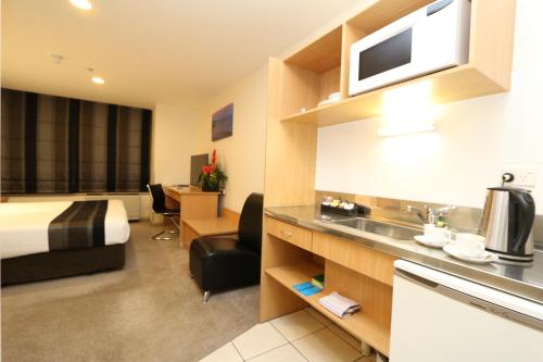 a hotel room with a bed and a kitchen at Edit Auckland Central in Auckland