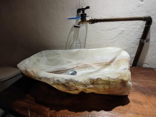a bathroom sink with a rock on a table at Chuchumbé Hotel & Hostal in Veracruz