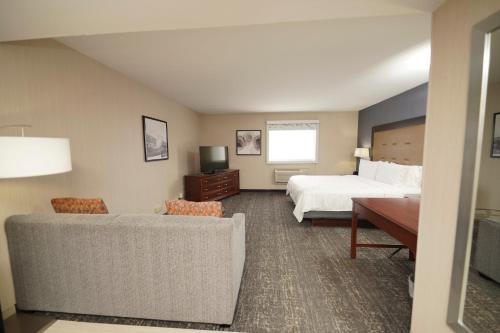 a hotel room with a bed and a couch at Holiday Inn & Suites Chicago-Carol Stream Wheaton by IHG in Carol Stream