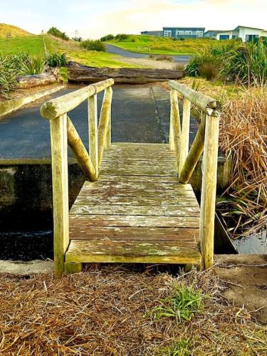 a wooden bridge on the side of a road at Luxury Absolute Ocean View Lodge in Waverley