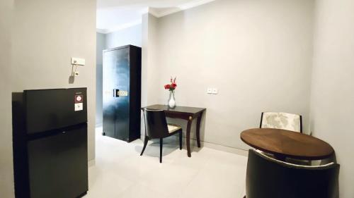 a room with a table and a black refrigerator at Puri Puspa Jimbaran in Jimbaran