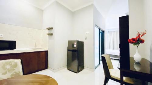 a kitchen and dining room with a table and a refrigerator at Puri Puspa Jimbaran in Jimbaran