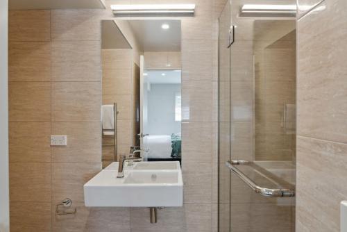 a bathroom with a sink and a shower with a mirror at Walter Peak View Apartment in Queenstown