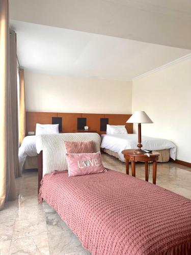 a bedroom with two beds and a red blanket at Turtledove Guesthouse in Kerobokan