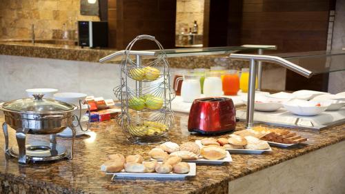 a buffet with bread and other food on a counter at Holiday Inn Orizaba by IHG in Orizaba