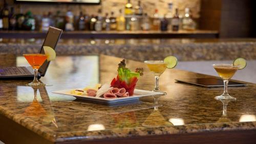 a table with a plate of food and two wine glasses at Holiday Inn Orizaba by IHG in Orizaba