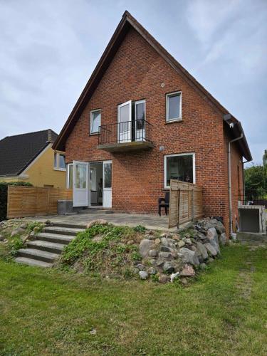 a brick house with a porch and a balcony at Cozy Townhouse Near Beach, Harbor, And Lalandia in Rødby
