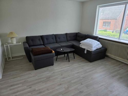 a living room with a couch and a table at Cozy Townhouse Near Beach, Harbor, And Lalandia in Rødby