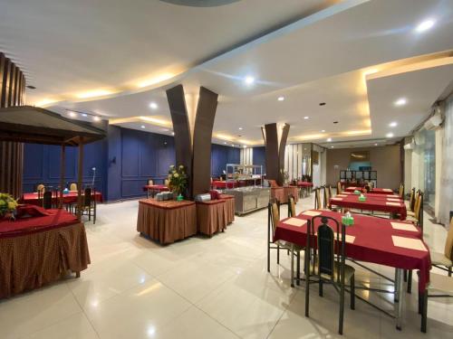 a restaurant with red tables and chairs in a room at Grand mansion hotel in Blitar