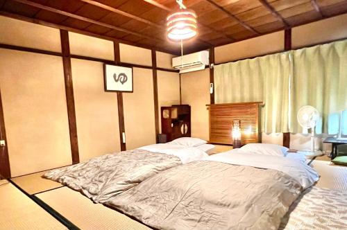 a bedroom with a large bed in a room at Guesthouse Naramachi in Nara