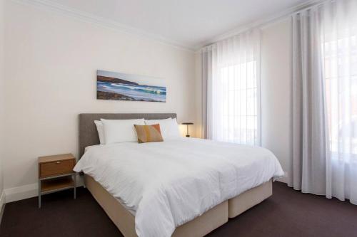 a white bedroom with a large bed and windows at Diamonds By The Dock Spacious,central Quality in Fremantle