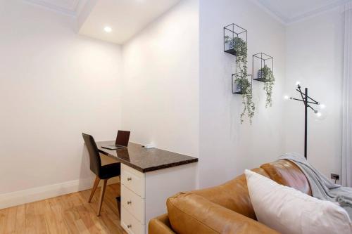 a living room with a couch and a desk with a laptop at Diamonds By The Dock Spacious,central Quality in Fremantle