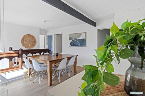 a dining room with a wooden table and a vase with a plant at Cowes On Hill in Cowes