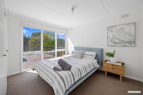 a bedroom with a bed and a large window at Cowes On Hill in Cowes