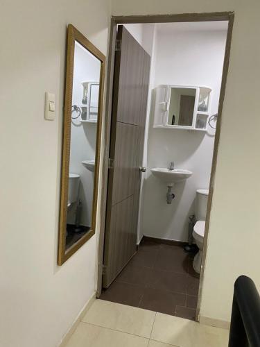a bathroom with a mirror and a sink and a toilet at Apartamento en Las Mercedes tipo Loft in Palmira