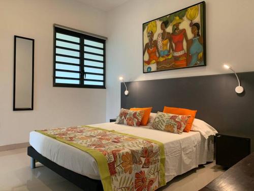 a bedroom with a large bed with orange pillows at Villa Zélie, avec piscine et proche du lagon in La Saline Les hauts 