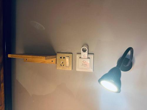 a light on a wall with a lightswitch and a light bulb at Por Chey Guesthouse in Battambang