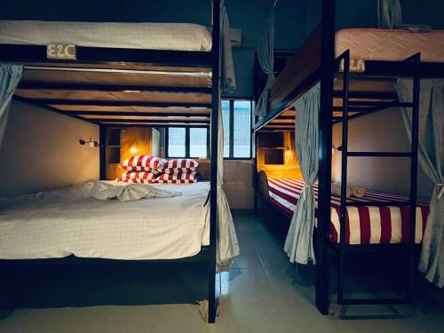 a bedroom with two bunk beds in a room at Por Chey Guesthouse in Battambang