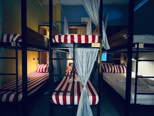 a bunk bed room with two bunk beds with curtains at Por Chey Guesthouse in Battambang