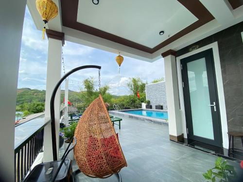 a porch with a swing next to a swimming pool at TuTu's Homestay Phong Nha in Phong Nha