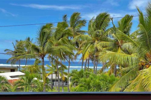 Blick auf den Strand und Palmen aus dem Fenster in der Unterkunft corail vert in La Saline Les hauts 