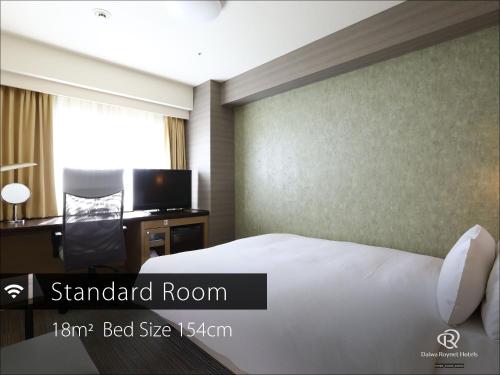 a bedroom with a bed and a desk and a tv at Daiwa Roynet Hotel Takamatsu in Takamatsu