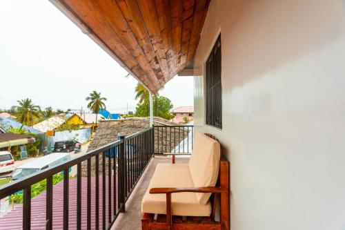 a balcony with a chair and a view of the ocean at Roots inn in Paje