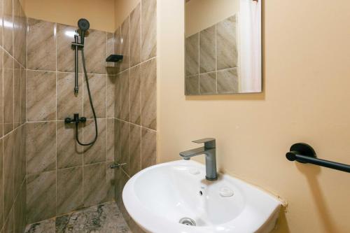 a bathroom with a sink and a shower at Roots inn in Paje